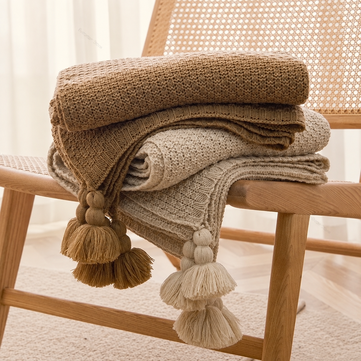 Plaids brun et beige pliés, maille texturée et pompons