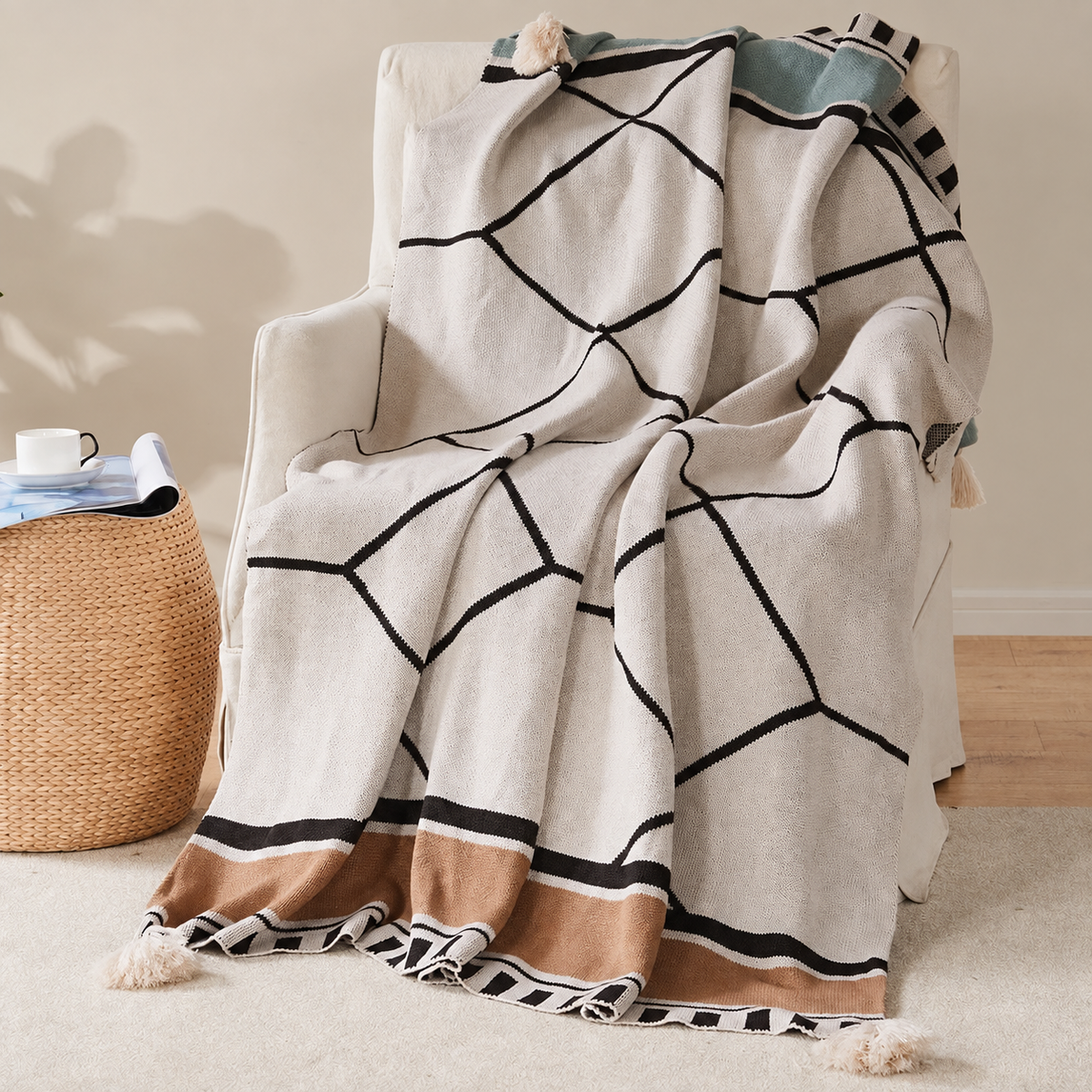 Plaid écru à lignes noires et bordure camel sur un fauteuil ivoire
