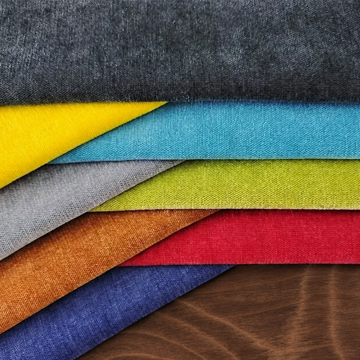 Échantillons de tissus chenille colorés superposés sur un support en bois
