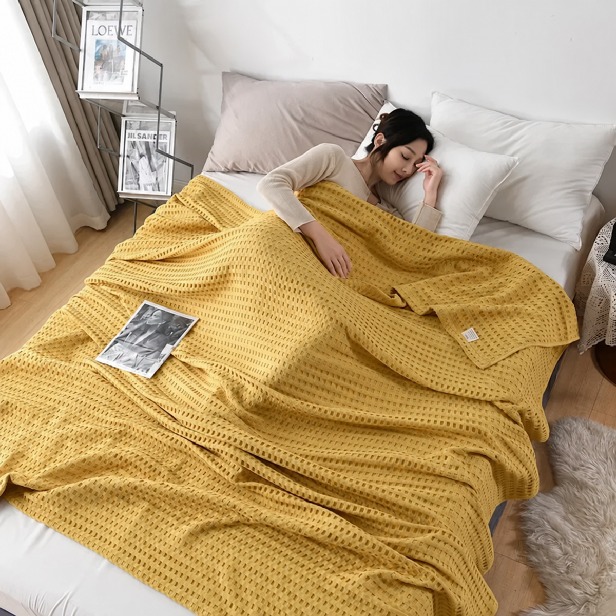 Plaid jaune moutarde gaufré sur un lit près de rideaux taupe