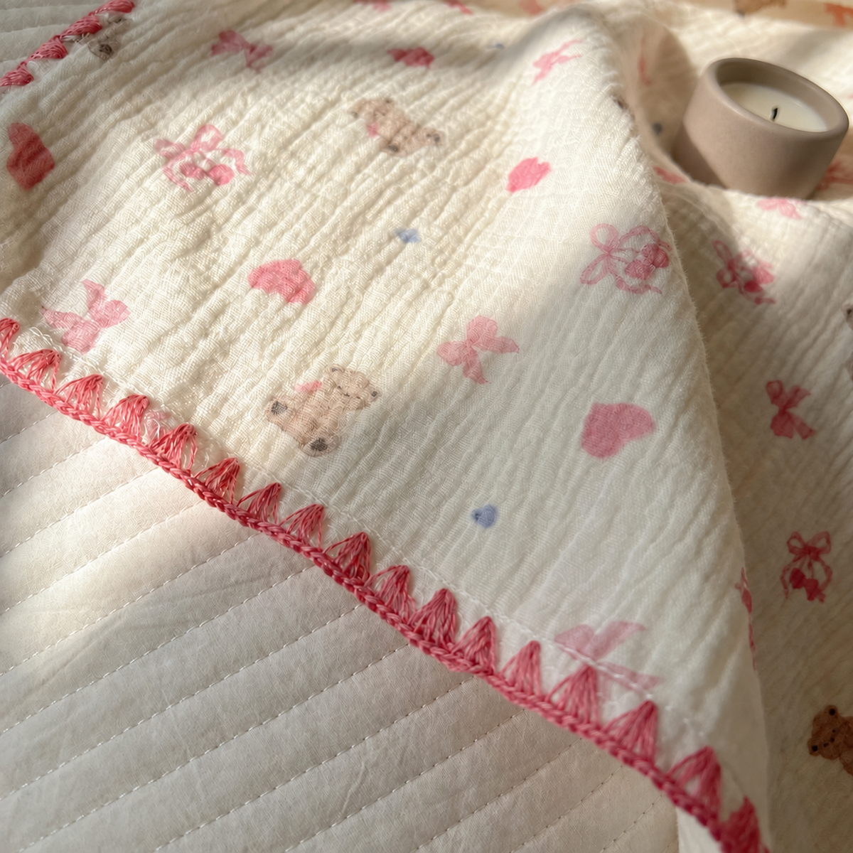 Détail du coton crêpe imprimé et de sa bordure rose avec un pot taupe