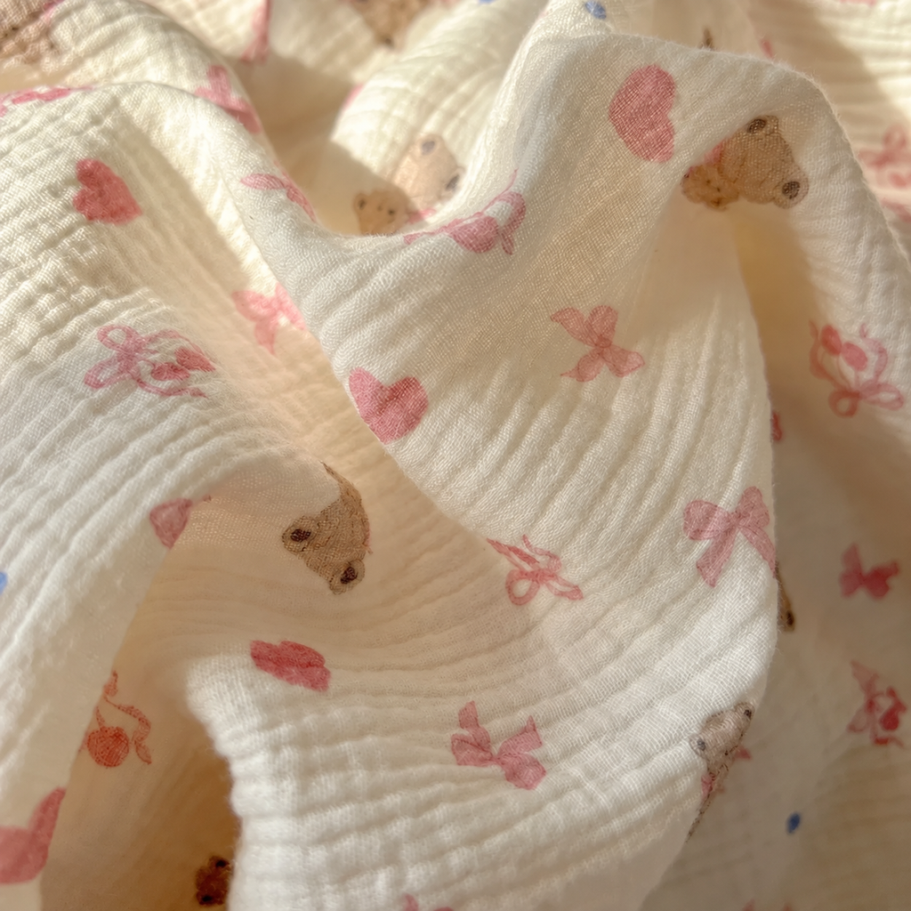 Gros plan sur les plis du coton crêpe à motifs oursons et cœurs roses