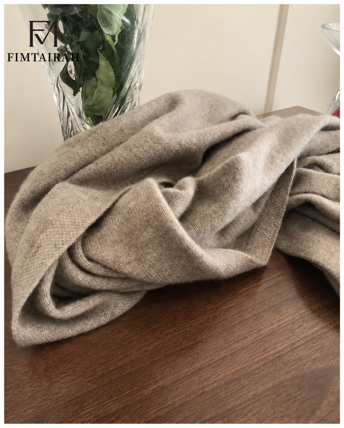 Détail de l’écharpe taupe à maille fine sur une table en bois