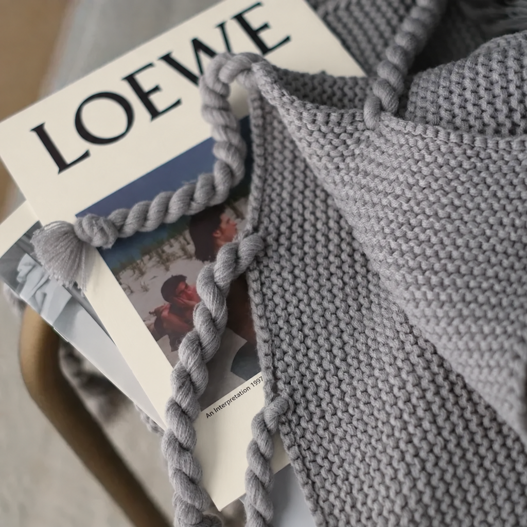 Détail de la maille et des franges torsadées du plaid gris