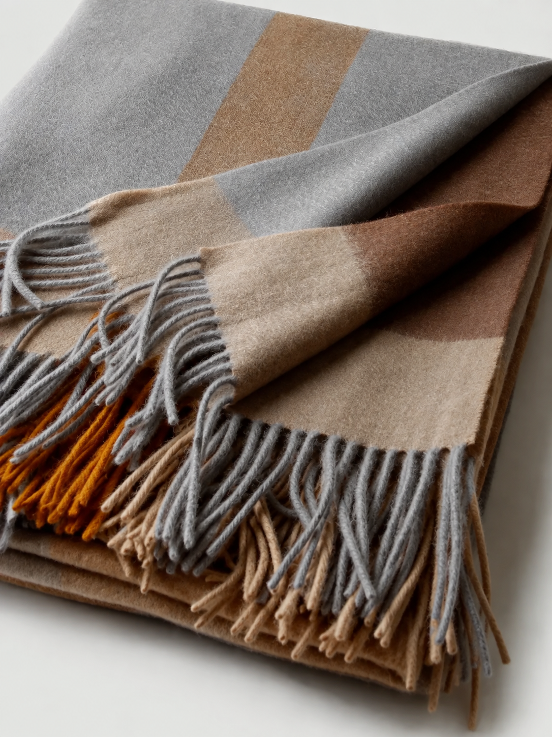 Détail du plaid jacquard gris brun et ocre avec franges réarrangées
