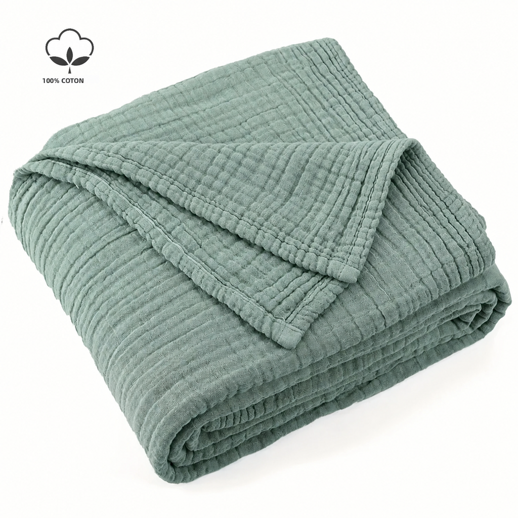 Plaid vert sauge en coton mousseline plié sur fond blanc